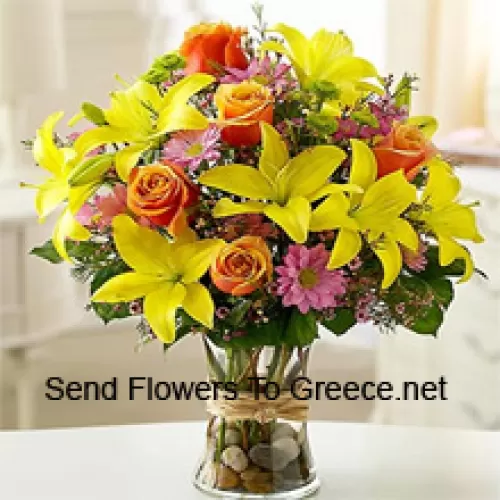 Gelbe Lilien, orangefarbene Rosen und rosa Gerbera mit saisonalen Füllstoffen in einer Glasvase