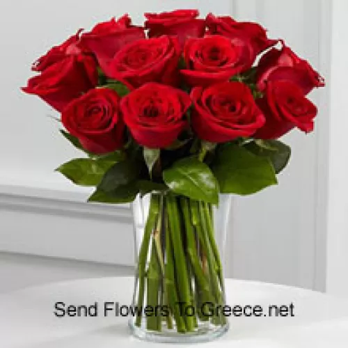 11 rosas rojas con algunos helechos en un jarrón